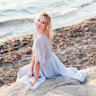 photographe mariage hauts-de-seine - Jeune mariée assise sur un rochers sur la plage en provence le soir de son mariage au crépuscule après son mariage à Nanterre dans les Hauts-de-Seine
