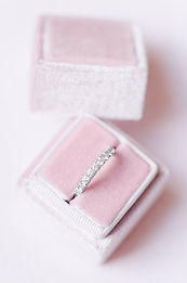 photographe mariage charente maritime - Boite à alliance en velours rose pâle sur fond rose poudré contenant une aliance tour de diamants en or blanc à La Rochelle en Charente-Maritime