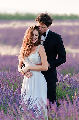 Photographe mariage deux-sèvres - Couple de mariés enlacés en robe et costume dans les champs de lavandes au crépuscule après leur mariage près de Niort dans les Deux-Sèvres