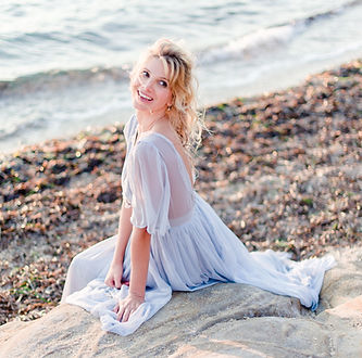 saint-tropez wedding photographer - Young bride sits on a rock at the beach in Provence on her wedding day at sunset next to saint-tropez in côte d'azur