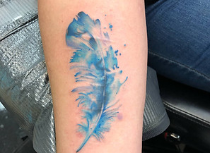 Detailed water color feather tattoo by Art & Ink Tattoo Gallery