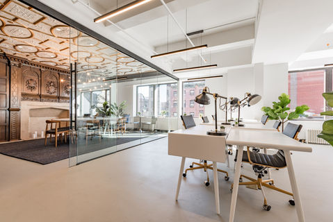 Modern workspace with white desks adjoining historic meeting room through glass wall at 80 Eighth Avenue.