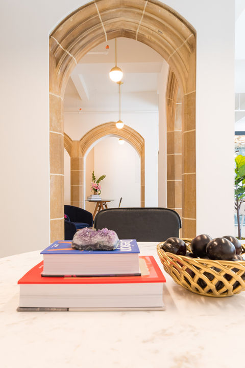 Reception lounge with blue velvet chairs and stone archway at 80 Eighth Avenue office renovation.