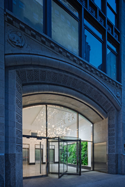 Custom Italian Bocci chandelier installation above lobby seating area in commercial entrance