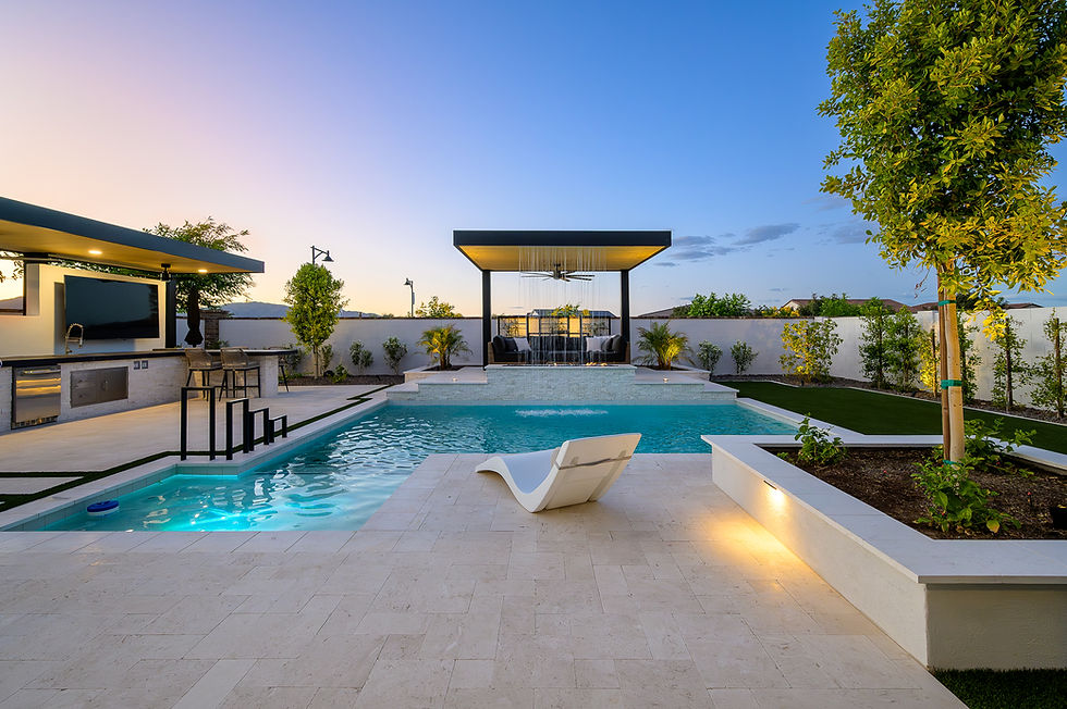 Luxury backyard with pool, water feature, paver flooring, outdoor kitchen, and pergola-covered lounge area with sofas.