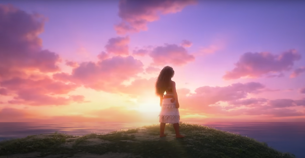 Vaiana sur une montagne devant un coucher de soleil