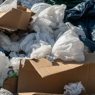 Gewerbemüll bestehend aus gefüllten schwarzen Säcken, Verpackungsmaterial und Kartons