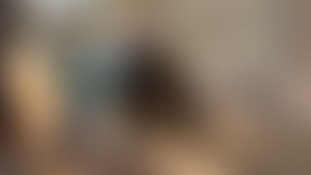 Dois operários de capacete cortam um grande tanque metálico enferrujado em uma área industrial.