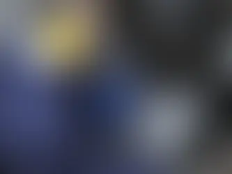 Técnico com fones amarelos mede ruído em máquina industrial, segurando aparelho com gráfico, em ambiente de manutenção.