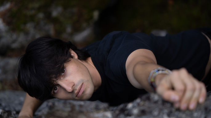 Rock climber reaching up to rock