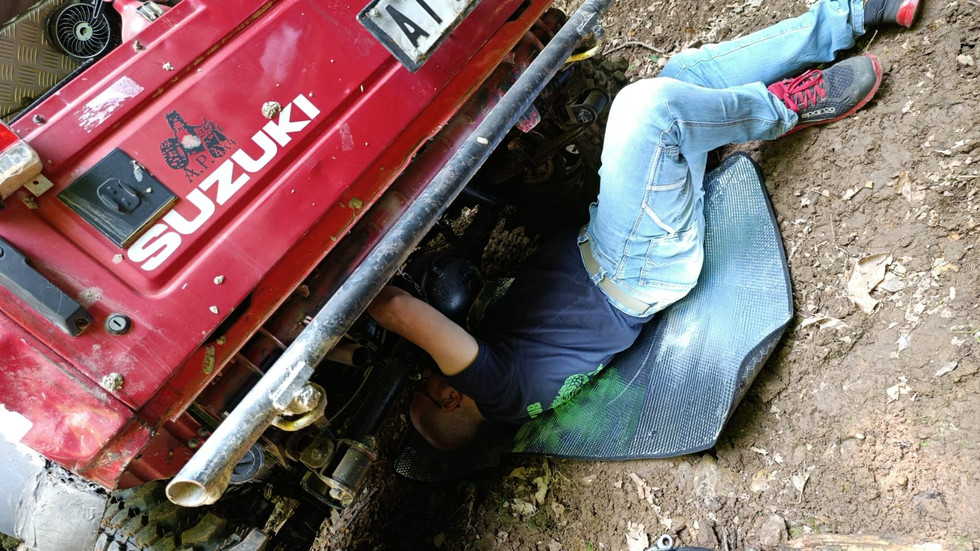 ragazzo sotto il suo Suzuki rosso, per un controllo ai ponti della sua macchina