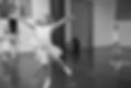 Black and white photo of a young girl leaping in a ballet class