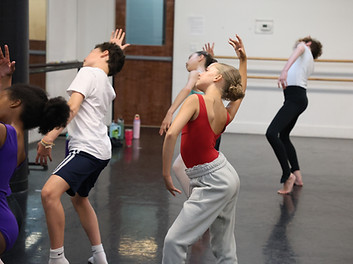 Young dancers in a modern dance class stretching in the mirror