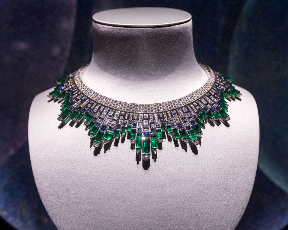 Diamond and emerald necklace displayed on white bust