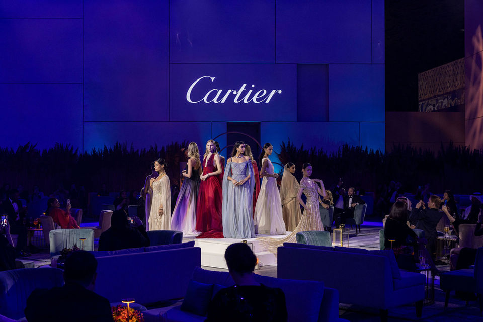Wide shot of blue lit stage with Cartier branding