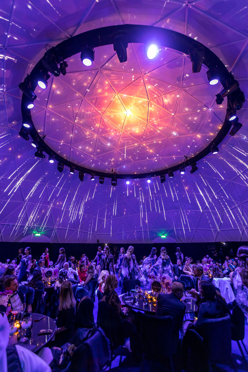 Looking up at purple and blue illuminated dome ceiling