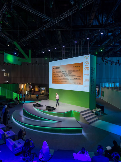 Wide shot of a conference stage with green lighting