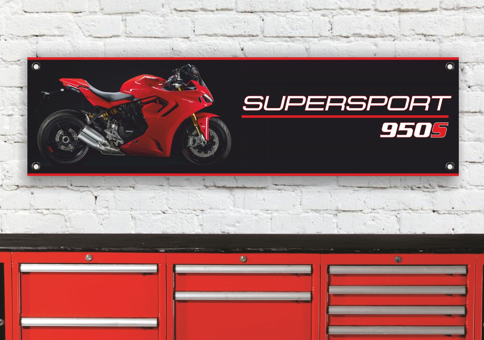 Red motorcycle sign reading Supersport 950 hanging above red tool chest.