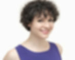 Headshot of Natasha Conti. A brunette with short curly hair wearing a purple shirt. Smiling.