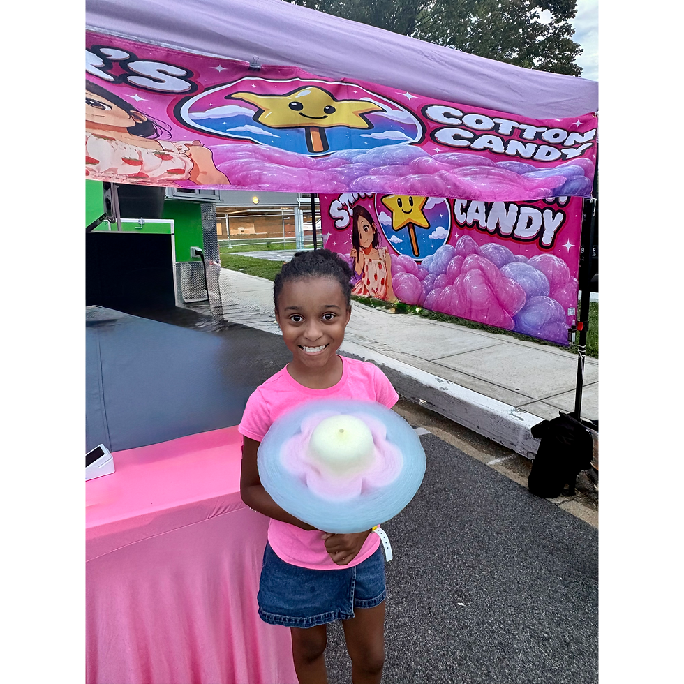 Girl holding flower-shaped cotton candy at a private party.