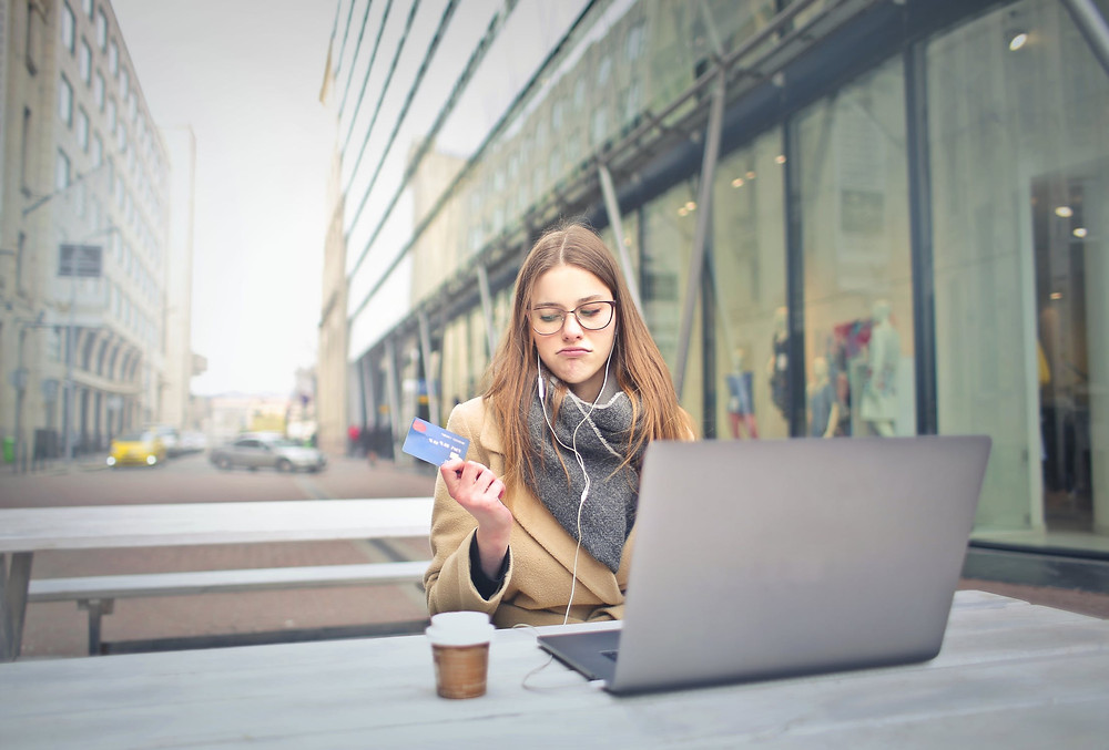 Woman thinking about paying with a credit card