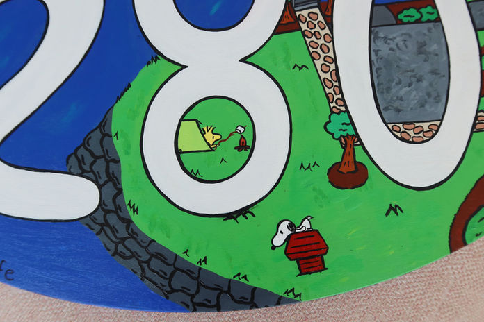 A colorful acrylic painting of a peaceful lakeside scene featuring a wooden dock, calm blue water, and lush green trees. An oval wooden sign displaying the number "280" sits in the foreground, representing a family lake house. Tiny Snoopy characters are hidden throughout the landscape, adding playful, nostalgic details that celebrate childhood memories, family traditions, and summers spent at the lake.