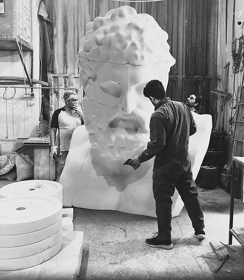 Armin Hesampour and his team meticulously sanding a monumental 3-meter tall Hercules bust sculpture carved from foam, showcasing large-scale creative fabrication and custom art projects by Art of Arm in Toronto.