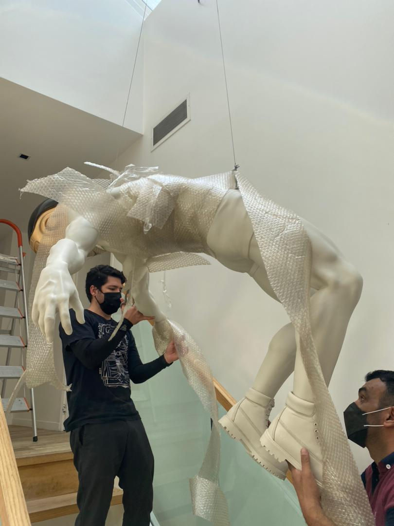 Suspended installation process of a custom figurative sculpture by Art of Arm