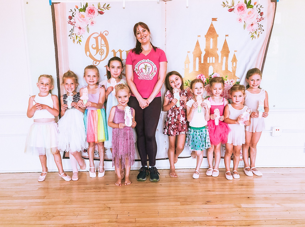 children and teacher pose in front of a bakdrop