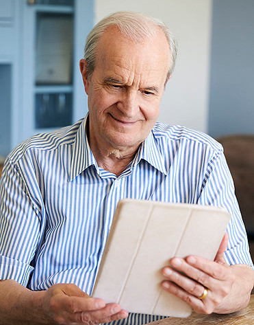 senior-man-sitting-at-home-using-digital
