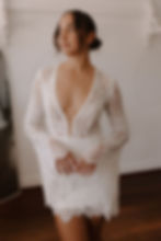 Close-up of Bella Mini gown showing deep V neckline, intricate lace, and scalloped edging.