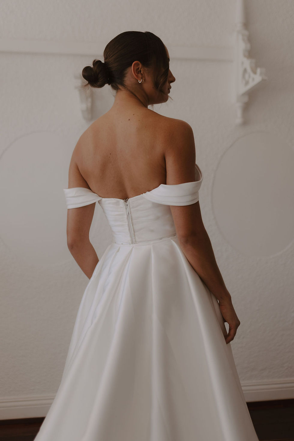 Thumbnail: Back mid-length view of the Sierra wedding dress showing structured bodice, detachable sleeves, and satin overskirt detailing