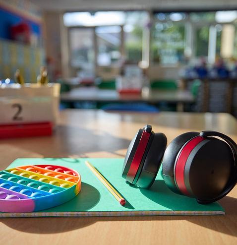 Ear Defenders Or Headphones And Fidget Toy To Help Child With ASD Or Autism On Table In Sc
