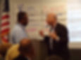 Two men actively engaged in a role-playing exercise on conflict resolution, demonstrating key negotiation techniques.