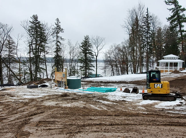 Septic excavation being performed with snow on the surrounding grounds