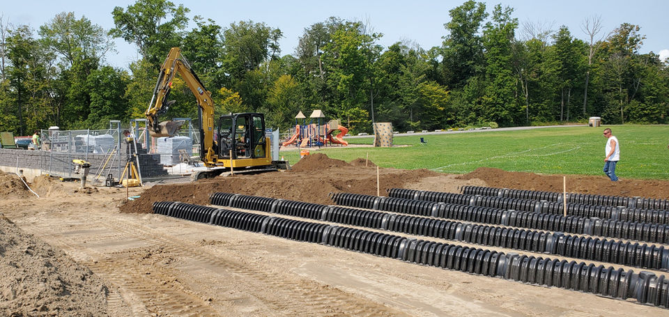 A large leach field septic system is placed in the ground next to a field
