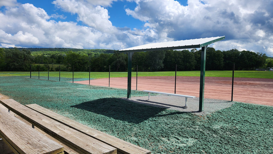Freshly laid hydroseed on the grounds next to a baseball field