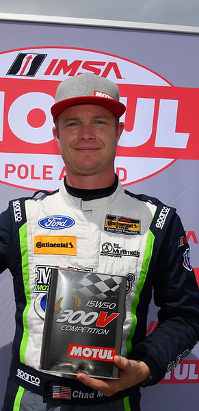 Chad McCumbee holding a pole winning trophy