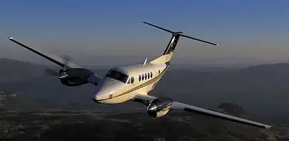 White and gold turboprop charter aircraft in flight