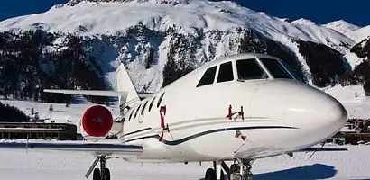 Private jet on a snowy runway with mountains