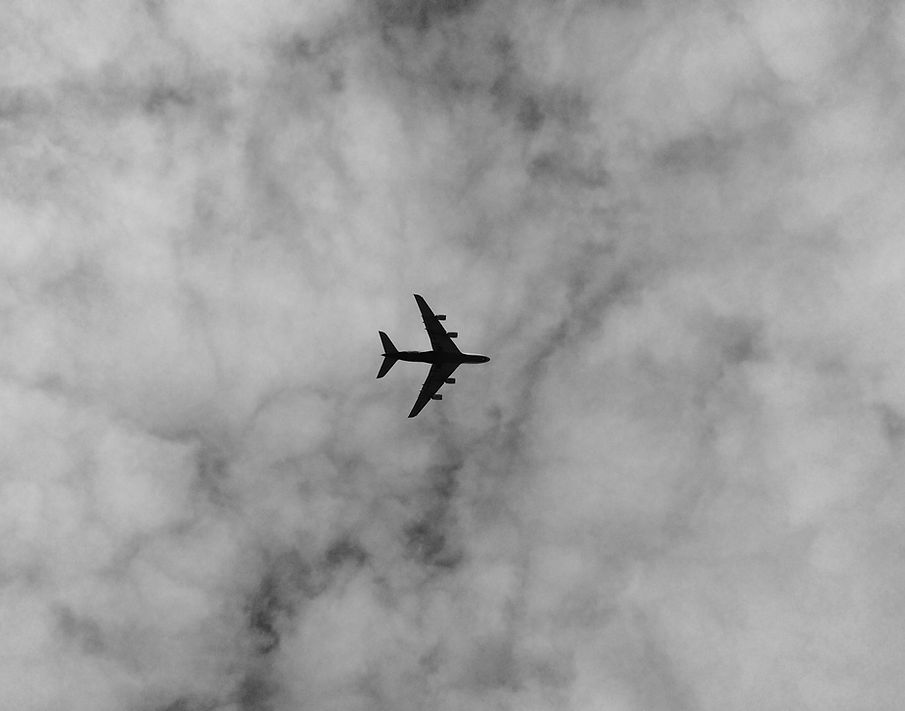 Airplane flying in cloudy sky