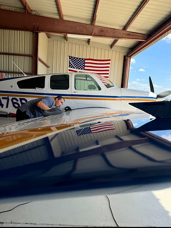 Man inspecting airplane wing in hangar
