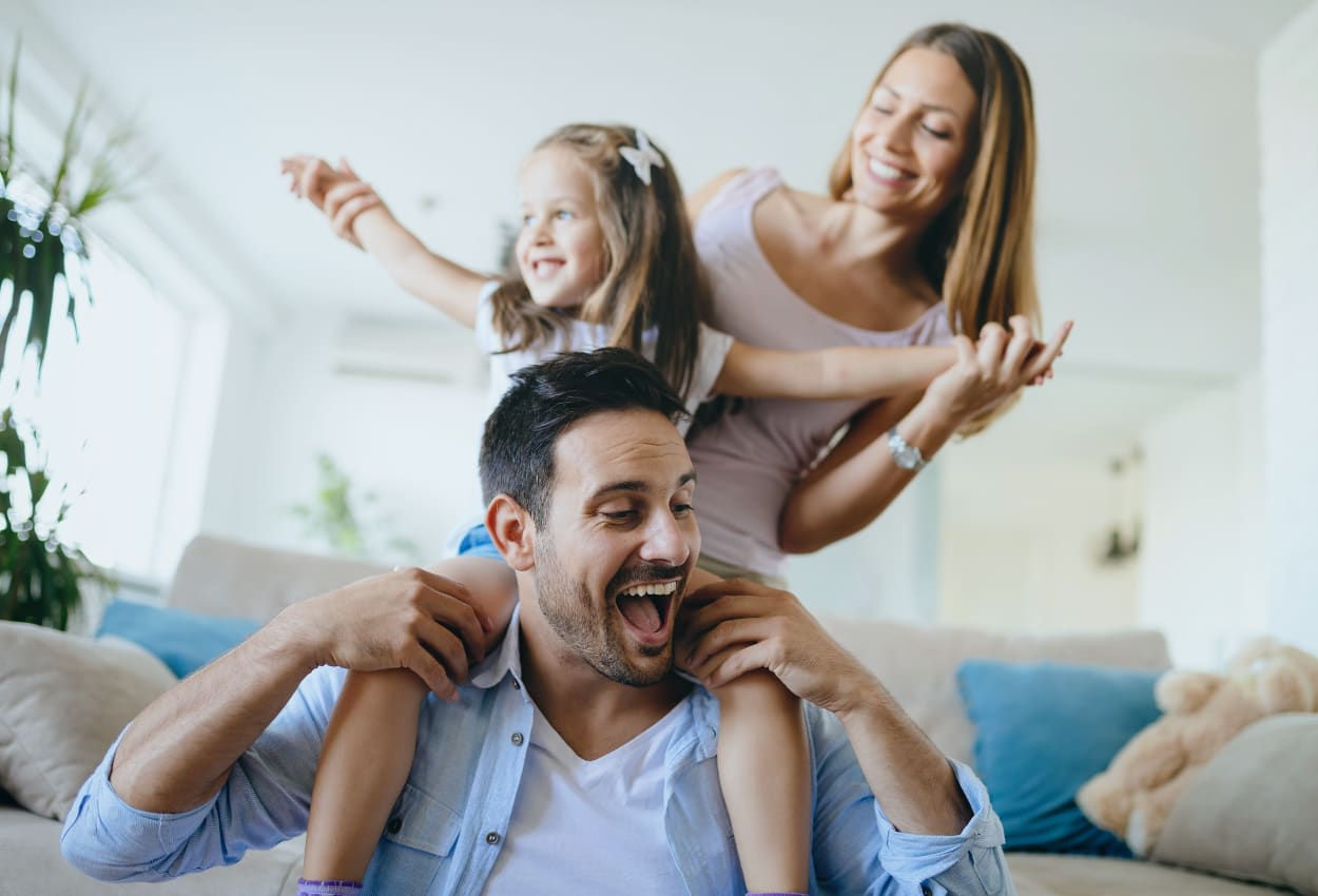 Happy family playing, father carrying daughter on shoulders