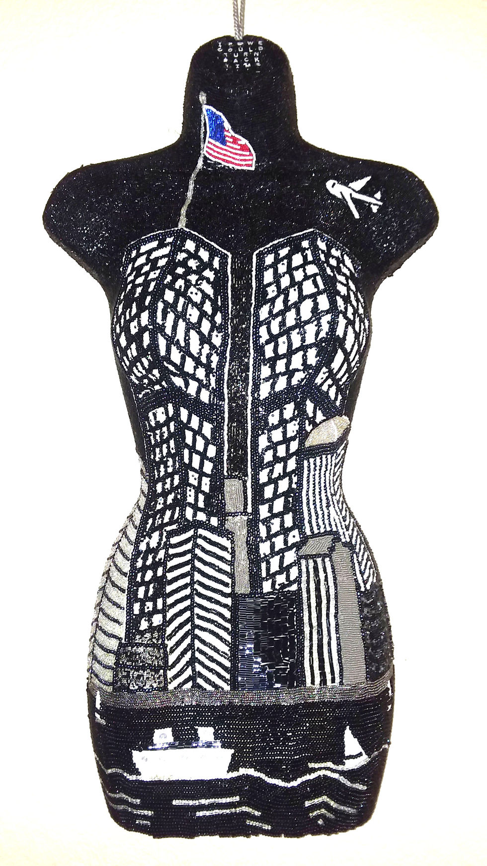New York's Twin Towers are memorialized in black and white beads on a female torso.
Offered at $2500.