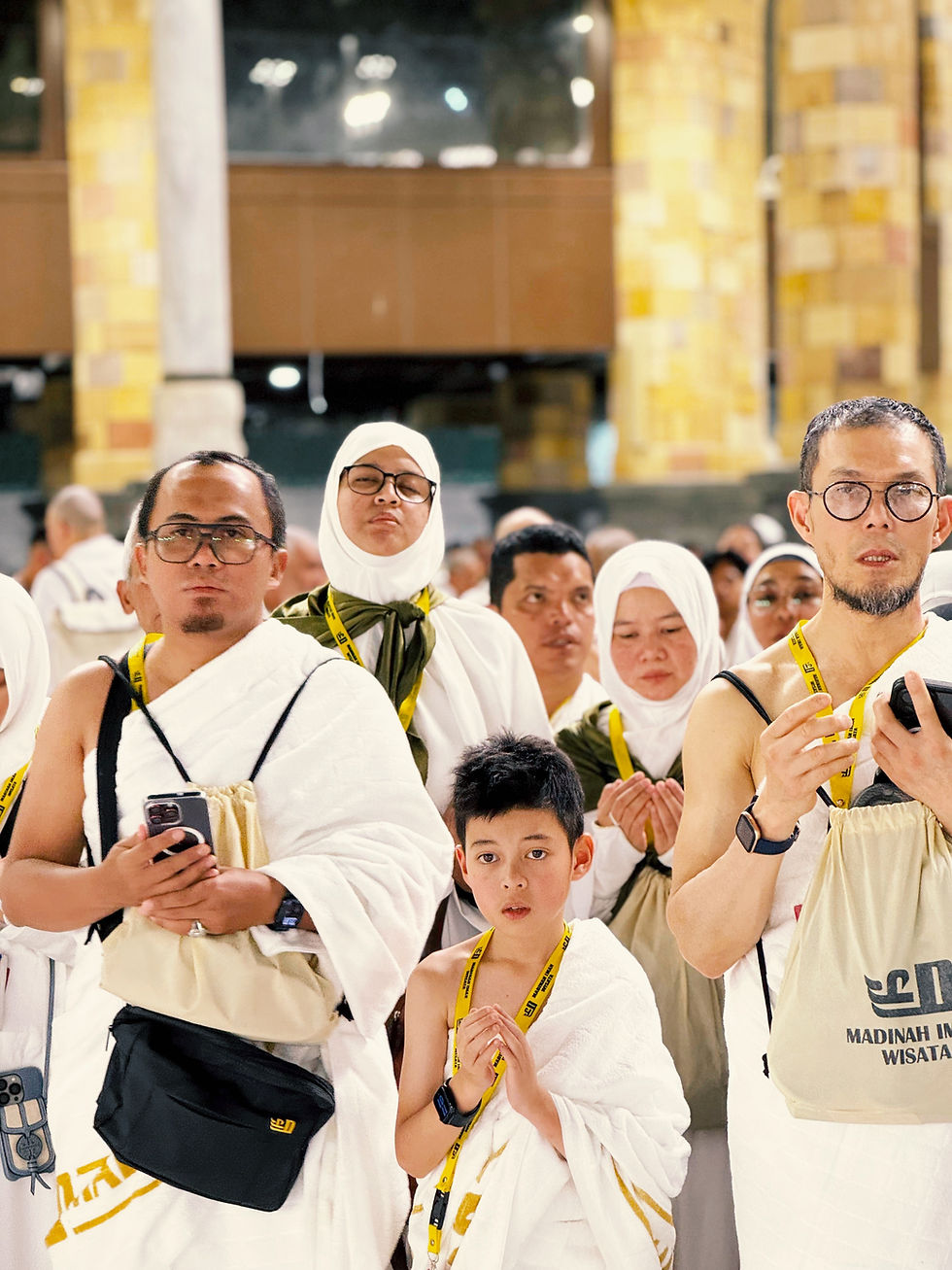 Pilgrims in white robes, with a child, looking forward