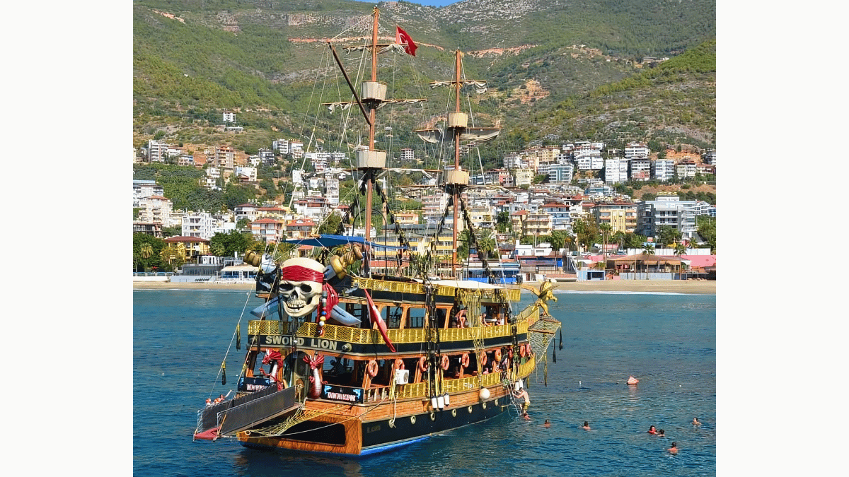 Boat anchored in a turquoise bay along the Alanya coast, part of Turcome’s full-day cruise.