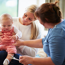 Health Visitor with mum and baby at home