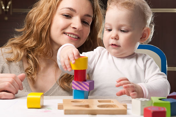 Mum and baby at table using building blocks