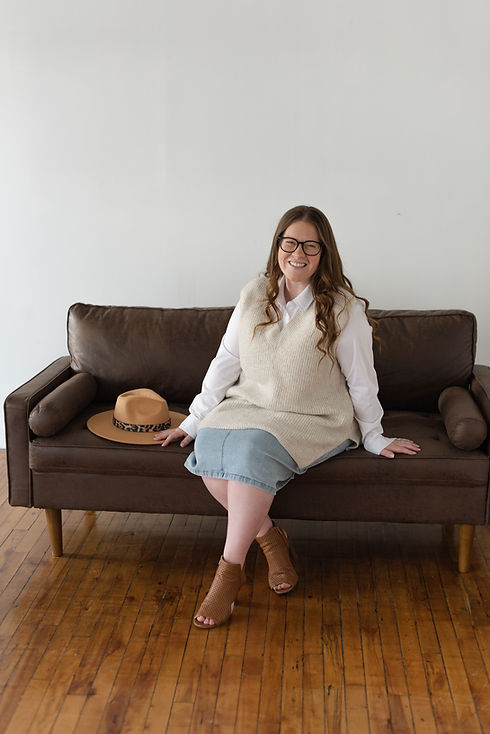 Woman posing for headshot on a couch