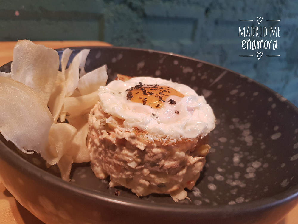 Ensaladilla rusa con huevo frito y chips de yuca.